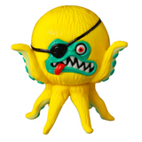 The VAG 40 — AHOY by Shelterbank, crafted by Medicom (JP), is a charming yellow toy octopus embodying the essence of Japanese vinyl toy design. It boasts a distinctive black eyepatch over one eye, a broad grin accentuated by sharp teeth, and a striking protruding red tongue. This piece makes for an enchanting addition to any gachapon figures collection!