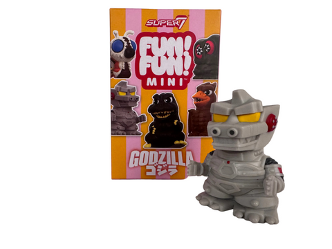 A small, gray Mechagodzilla mini figure from the Toho Fun! Fun! Godzilla Mini Blind Box standing in front of its illustrated product box.