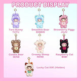 Seven Nommi Loveliness Never Ends Plush Blind Box keychains: a purple bunny, blue bear, pink pig, brown bear, cream sheep, black cat, and a tan cat with a gold coin.