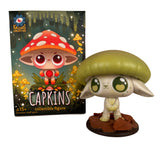 A Capkins Series 1 Blind Box figure from Kaleidos Creative—with a green mushroom cap—stands on its base beside the illustrated packaging showing a red-capped character and the Kaleidos Creative logo.