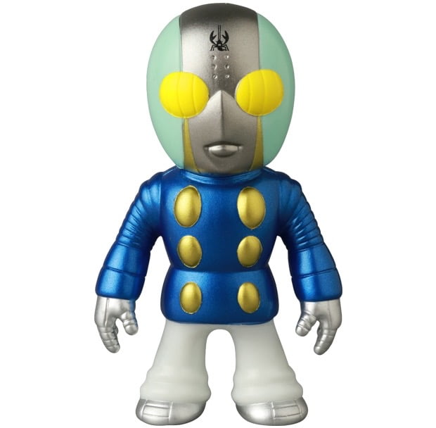The Medicom VAG 46 — Tane Man is a collectible vinyl figure featuring a green oval head, yellow eyes, and a blue suit with gold buttons—ideal for fans of Japanese vinyl toys and gacha figures.