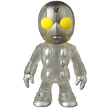 VAG 46 — Tane Man by Medicom is a small, silver and translucent Japanese vinyl toy with large yellow eyes, round body details, and a black forehead symbol—perfect for gachapon fans and Vinyl Artist Gacha collectors.