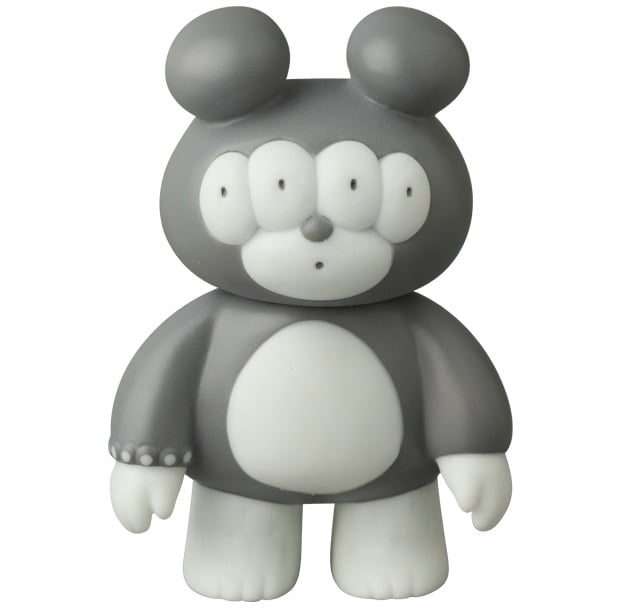 The VAG 46 — Matthew by Medicom is a gray and white cartoon bear figure with four eyes, round ears, and a large oval-shaped belly, standing upright. Its design echoes the Japanese vinyl style of Vinyl Artist Gacha gachapon figures.