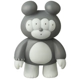 The VAG 46 — Matthew by Medicom is a gray and white cartoon bear figure with four eyes, round ears, and a large oval-shaped belly, standing upright. Its design echoes the Japanese vinyl style of Vinyl Artist Gacha gachapon figures.