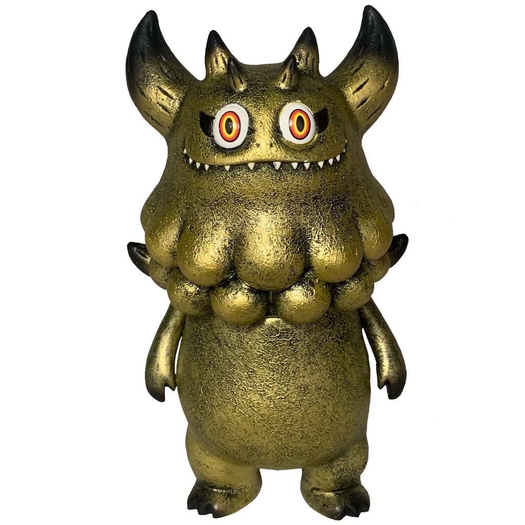Rangeas Jr. - Gold Patina by The Little Hut (HK) is a gold textured monster figure with horns, sharp teeth, red and yellow eyes, and round neck bumps—an eye-catching collectible toy displayed upright on a white background.