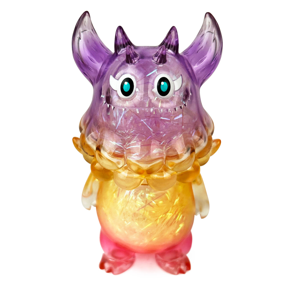 The Little Hut (HK)'s Rangeas Jr. — Soft Clear is a toy figure with a translucent body in purple, yellow, and pink hues, featuring horns, large eyes, and a wide mouth.