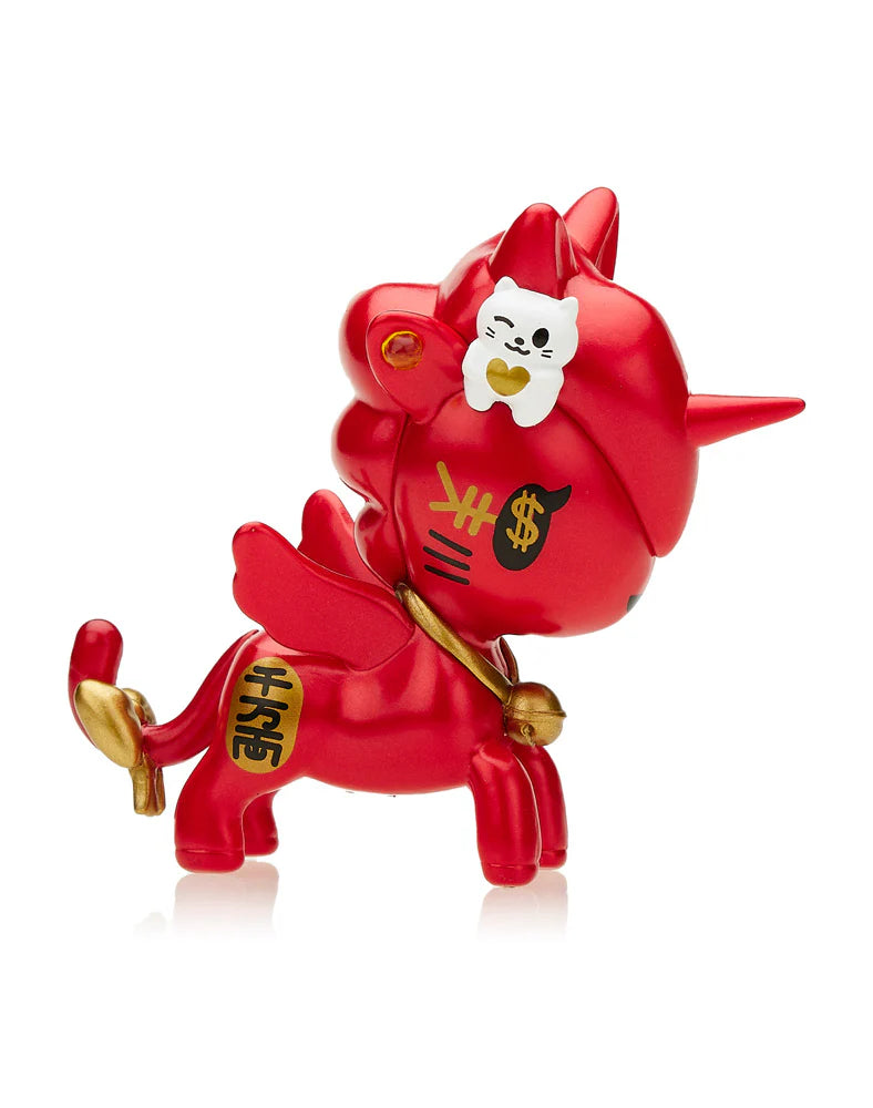 The Tokidoki Lucky Unicorno Blind Box figurine, from the renowned brand Tokidoki, showcases a red unicorn with wings that is embellished with dollar signs and Chinese characters symbolizing good fortune, along with a white cat sitting atop its head.