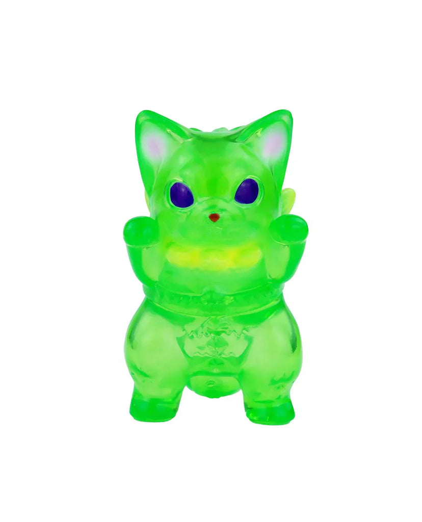 The Mamera-Tropical by Rotofugi is a translucent green cat figurine with upright paws, purple eyes, and a red nose, inspired by Japanese lucky cats and shown on a white background.