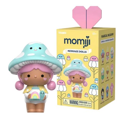 A pastel-hued, mushroom-themed Momiji Magical Meadow Message Doll by Rotofugi with pink hair stands beside its yellow blind box, decorated with similar doll art—ideal for fans of collectible figures and enchanted adventures.