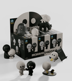 A display box of Kaleidos Creative's Meyanmi Shadow Blind Box features black and white collectible figures in playful poses—standing, hugging, or lying down—arranged in front of the blind box.