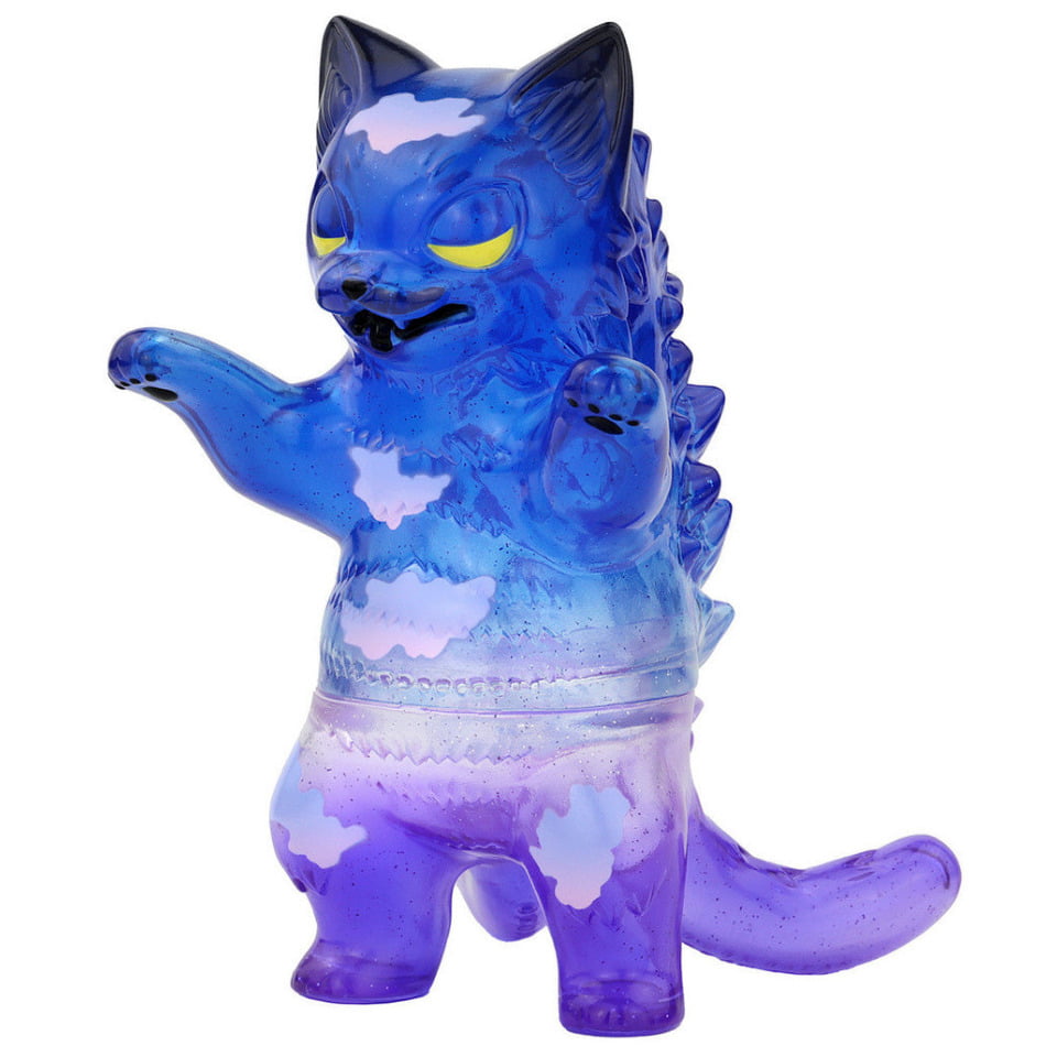The Negora - Sky View Twilight by Konatsuya is a blue and purple translucent vinyl toy, featuring a chubby cat design with yellow eyes and cloud-like patches—a playful addition to any collectible shelf.