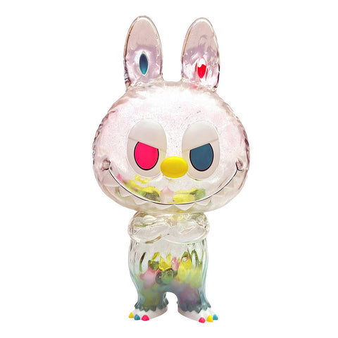 Cowowa- Vibrant by Rotofugi is a transparent, rabbit-shaped figure with multicolored accents inside, heterochromatic eyes, a yellow nose, and colorful toes, shown standing upright against a white background.