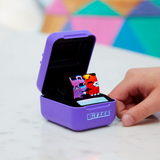 A person holding a Bitzee - Interactive Digital Pet box with a ring in it, equipped with an LED light strip.