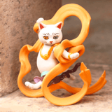 A HitenNeko Flying Cat - Blind Box figure with an orange tail is sitting on a stone.