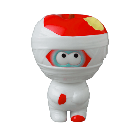 This Japanese vinyl toy features a character wrapped in white bandages with a red apple head, peering through the bandages with wide eyes. The figure is donned in a white suit with a red tie, capturing the quirky essence of VAG 36 - Yummy Mummy by Medicom (JP).