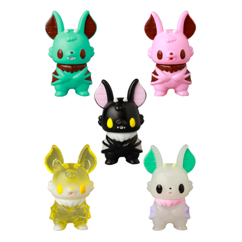 Five vibrant bat-like VAG 10th Anniversary — Kopatapatan figures by Medicom (JP) are arranged in a semicircle. Each Japanese vinyl toy features large ears, fangs, and comes in black, pink, green, yellow, or white with bold accents.