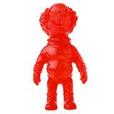 A red translucent toy figure with a bulbous head, curly hair, and a detailed face wearing a spacesuit stands upright, reminiscent of Japanese vinyl toy art. The VAG 36 - Deadman by Medicom (JP) captures the charm and intricacy often found in gachapon figures.