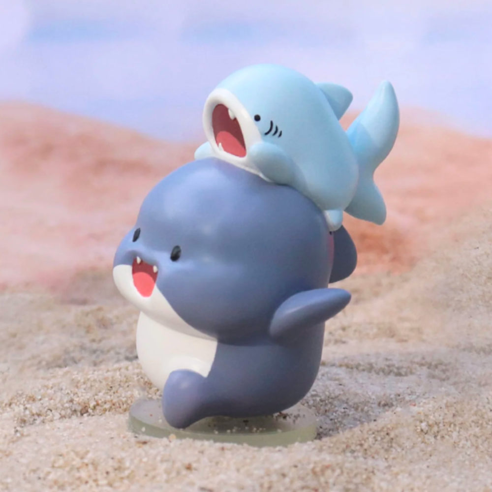 Two Shahimi Shark figures from the Series 2 Blind Box by Partner Toys playfully interact on a sandy surface, as if they’ve just emerged from an exciting blind box surprise.