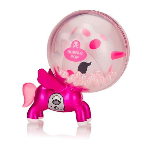 A small, pink, machine-shaped toy with a spherical, transparent top labeled "Tokidoki Candy Unicorno Bubble Pop (Limited Edition)." Inside the sphere are various pink and white beads reminiscent of bubble gum. The toy has four legs and a tail, fitting seamlessly into the whimsical tokidoki (IT) collection.