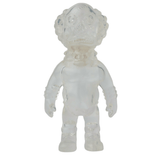 A clear, translucent toy figure of a humanoid character crafted in the style of a Japanese vinyl toy with a textured, round head and detailed limbs, resembling a small astronaut or alien. This collectible is reminiscent of the VAG 36 - Deadman by Medicom (JP).