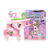 A pink unicorn figurine, enchantingly styled, dons a witch hat and is accompanied by a green snake and purple spider. It stands proudly in front of a Tokidoki Mystic Magic Unicorno Blind Box, adorned with similar mystical artwork.