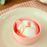 The Teacup Creatures — Cat Blind Box by Partner Toys features a realistic cake shaped like a pink and white sleeping cat nestled inside a teacup on a plate.