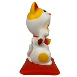 A white Dreams Sonny Angel Lucky Cat Collectors Trophy figurine sitting on a red base.