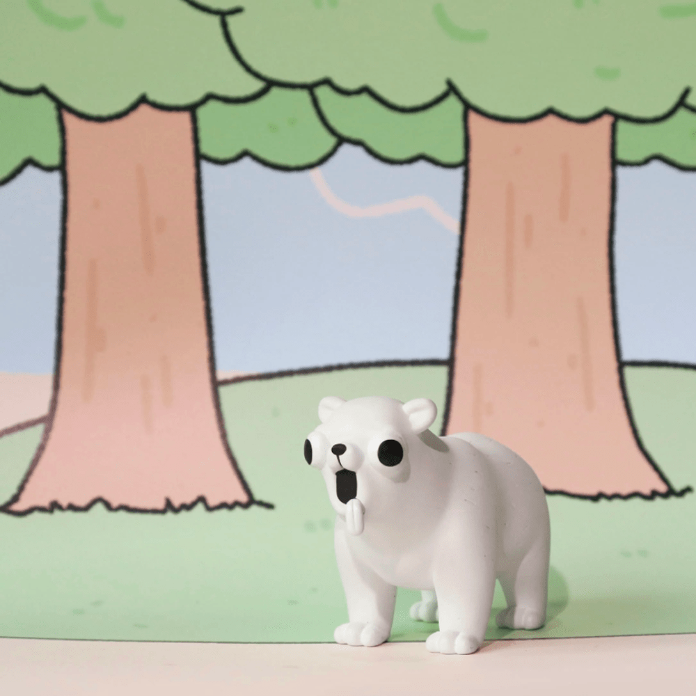 A white toy bear with exaggerated black eyes and open mouth stands on a pastel green surface before a cartoon forest, resembling one of the quirky figures from the Godgwawa — Weird Animals Blind Box by Partner Toys.