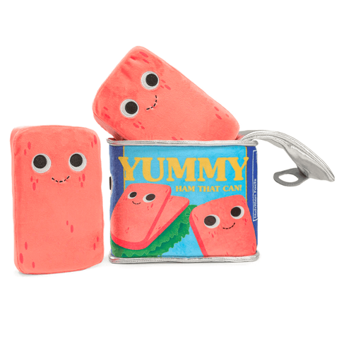 The Kidrobot (US) Pam the Ham Can — Yummy World Plush set features a blue can labeled "Yummy Ham That Can!" with two pink plush hams inside, all with smiling cartoon faces.