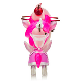 A small, pink, unicorn-like figurine with wings and a dessert theme, featuring a cherry on top of its head—part of the charming Tokidoki Café Cuties Unicorno - Cherry Blossom (Special Edition) collection.