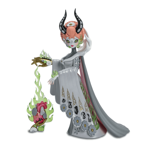 A Kidrobot (US) Junko Mizuno - Witch Queen 8" Vinyl Art Figure with ornate details, featuring a character resembling Junko Mizuno's style, adorned in a flower-decorated dress and horns, holding a creature with green flames, standing on a white background.