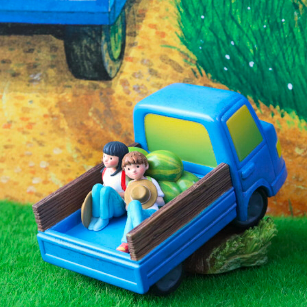 The Starry Night Blind Box by Partner Toys (TW) features a blue truck with two whimsical figures—one with a hat and another with straight hair—and two watermelons in the back, all set amidst green grass against a painted backdrop, creating a delightful scene.