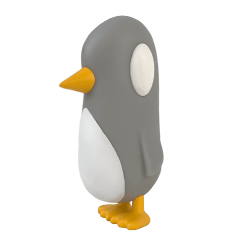The "Old Friend — Gray Days" figurine by Strange Cat features a gray and white penguin with yellow beak and feet, standing upright and looking left as if eager to catch up with an old friend, set against a white background.