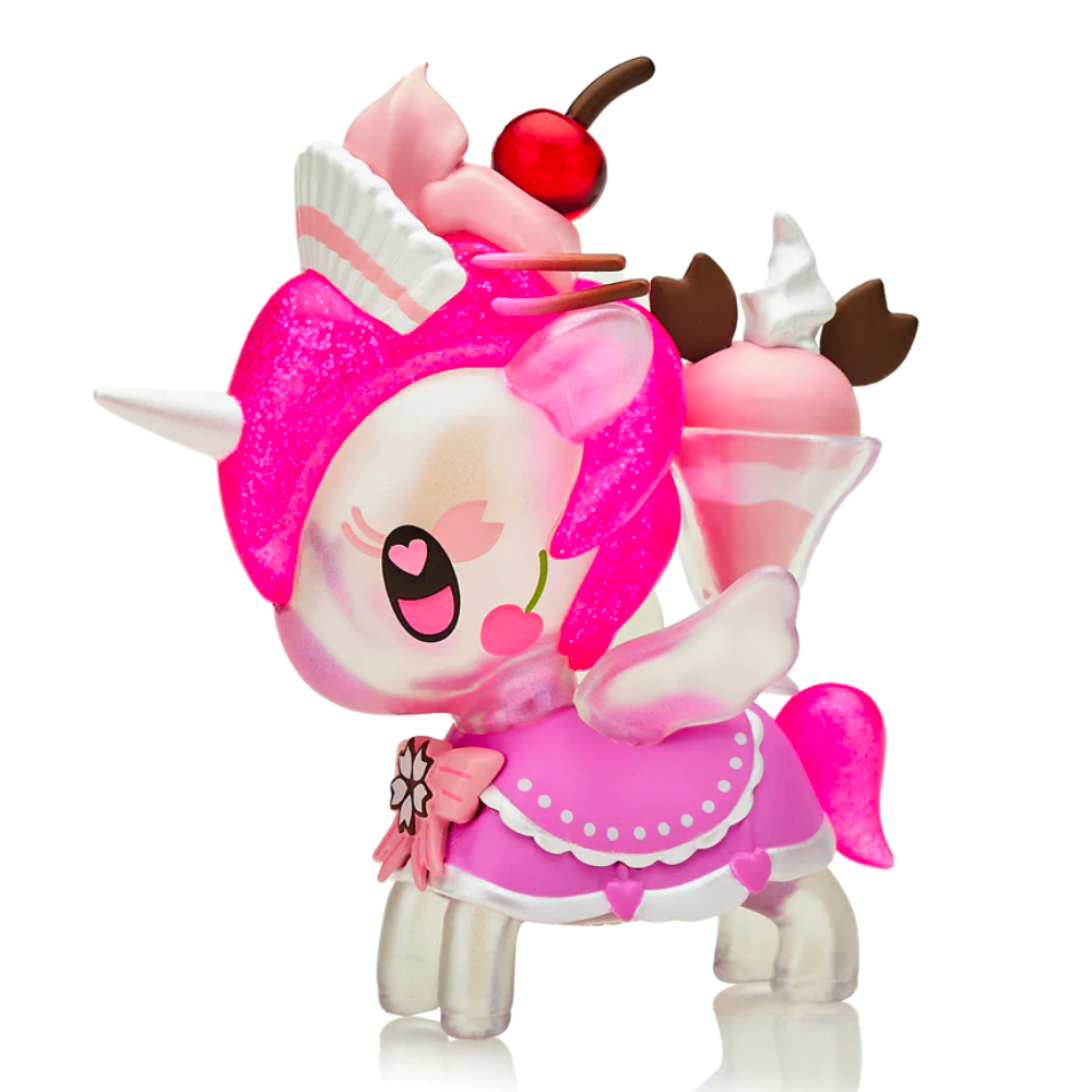 The Café Cuties Unicorno - Cherry Blossom (Special Edition) by Tokidoki is a colorful unicorn-like figurine adorned with pink and white accents, inspired by tokidoki, and decorated with delightful ice cream-themed elements including a sundae, whipped cream, and a cherry on top.