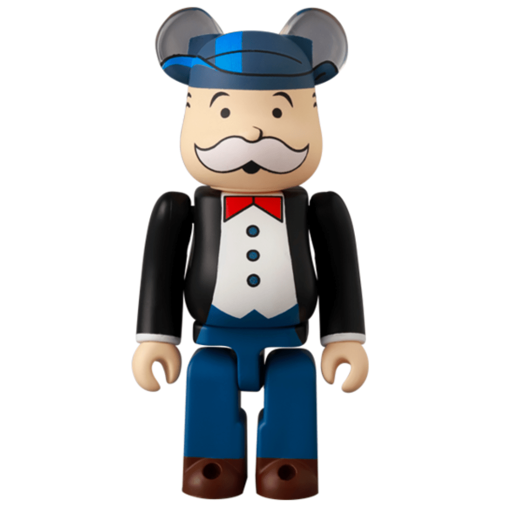 The Medicom (JP) Be@rbrick Series 49 Blind Box figure resembles a classic toy with round ears, a blue hat, tuxedo, red bow tie, matching blue pants, and a charming mustache. Discover it as part of an exciting blind box collection.