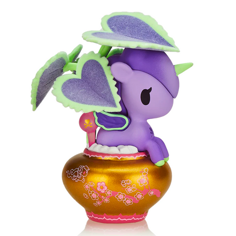 A Tokidoki Botanical Unicorno - Piantina (Special Edition) sits in a decorative gold pot, with green and purple heart-shaped Coleus plant leaves sprouting from its back, making it a perfect addition to the tokidoki (IT) collection.