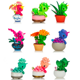 Colorful collectible plant-themed figurines arranged in a 3x3 grid. Each Tokidoki Botanical Unicorno - Blind Box combines an animal character with various plant elements and is placed in different styled pots, offering the excitement of a Blind Box reveal.