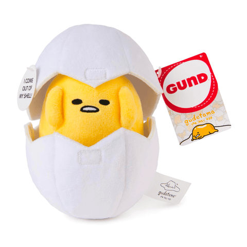 The 5" Gund Gudetama in an eggshell plush features a yellow egg character playfully peeking from its shell, with attached tags showcasing the Gund logo and Gudetama branding.