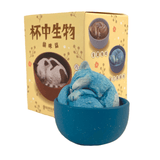 The Teacup Creatures — Cat Blind Box by Partner Toys contains a small, elegant blue and white cat figurine curling in a teacup. The decorative blind box features various delightful random cat-in-cup designs.