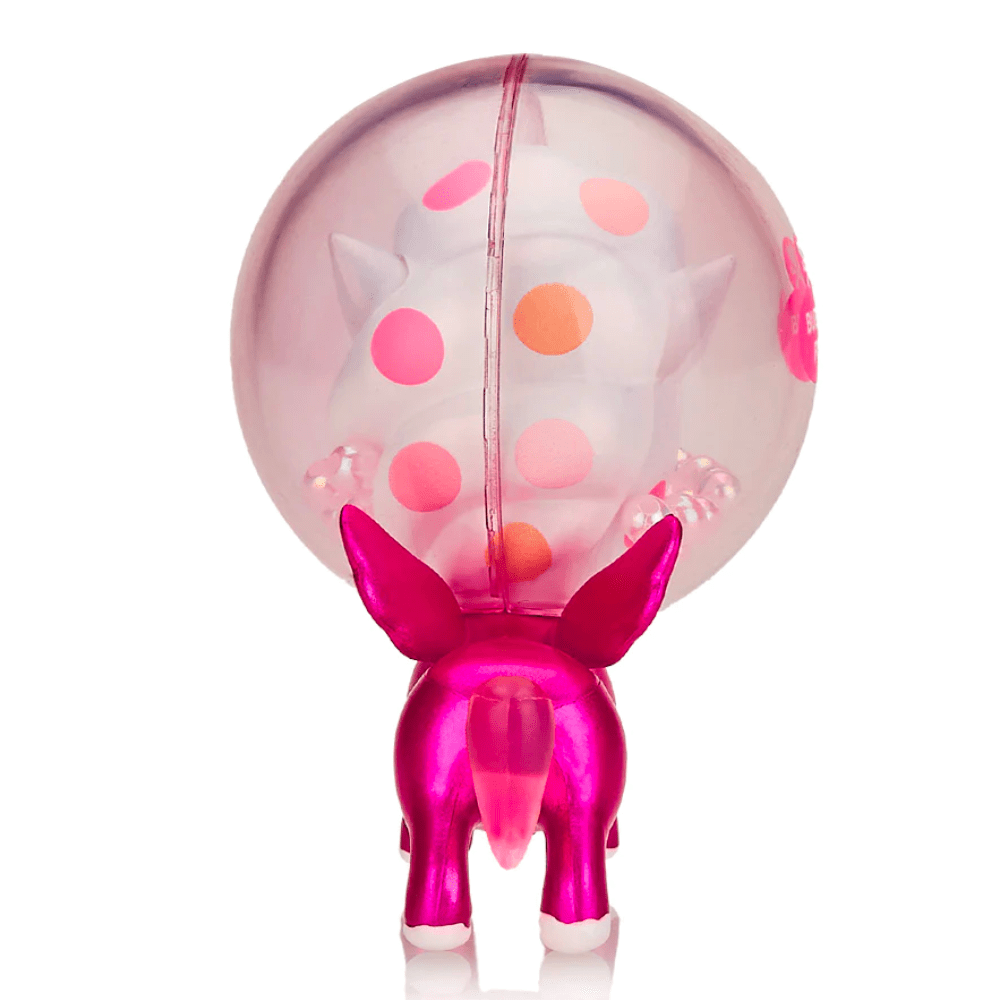 A Tokidoki Candy Unicorno Bubble Pop (Limited Edition) by tokidoki (IT) stands with its rear facing the camera, encased in a transparent, spherical bubble decorated with pink and orange polka dots, reminiscent of a whimsical tokidoki creation.