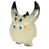 Introducing the Rangeas Rex Jr. — Glow by The Little Hut (HK): A small creature figurine with a translucent body, blue eyes, yellow eyebrows, and sharp, metal-like spikes on its head.