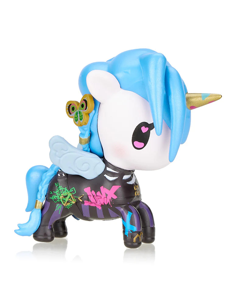 Introducing the Tokidoki x Arcane League of Legends Jinx Limited Edition: a vibrant unicorn figurine by Tokidoki featuring a blue mane, gold horn, and graffiti-style designs. This whimsical piece also includes wings and a small butterfly perched near its ear, echoing the enchanting worlds inspired by Arcane: League of Legends.