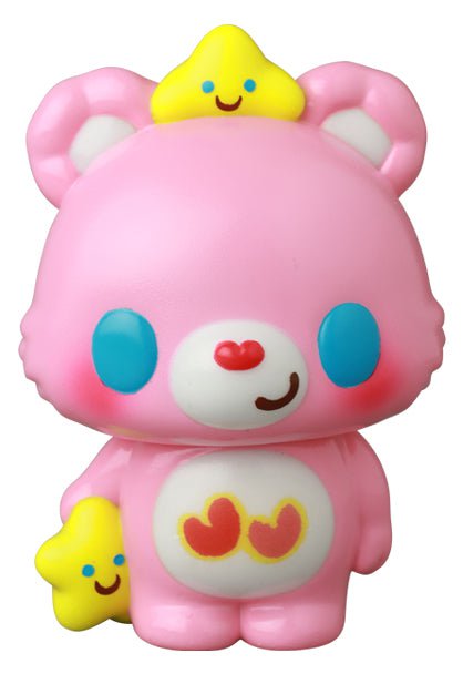 The VAG 42 — Care Bears by Medicom (JP) is a pink bear figurine with blue eyes, holding a yellow star and wearing another on its head—both smiling. Heart shapes decorate its belly, capturing the charm of Japanese vinyl gachapon collectibles.
