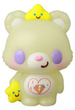 This cream-colored bear figurine with purple cheeks, holding a yellow star and wearing another on its head, features a gemmed heart on its belly—VAG 42 Care Bears by Medicom (JP), part of the Vinyl Artist Gacha series.