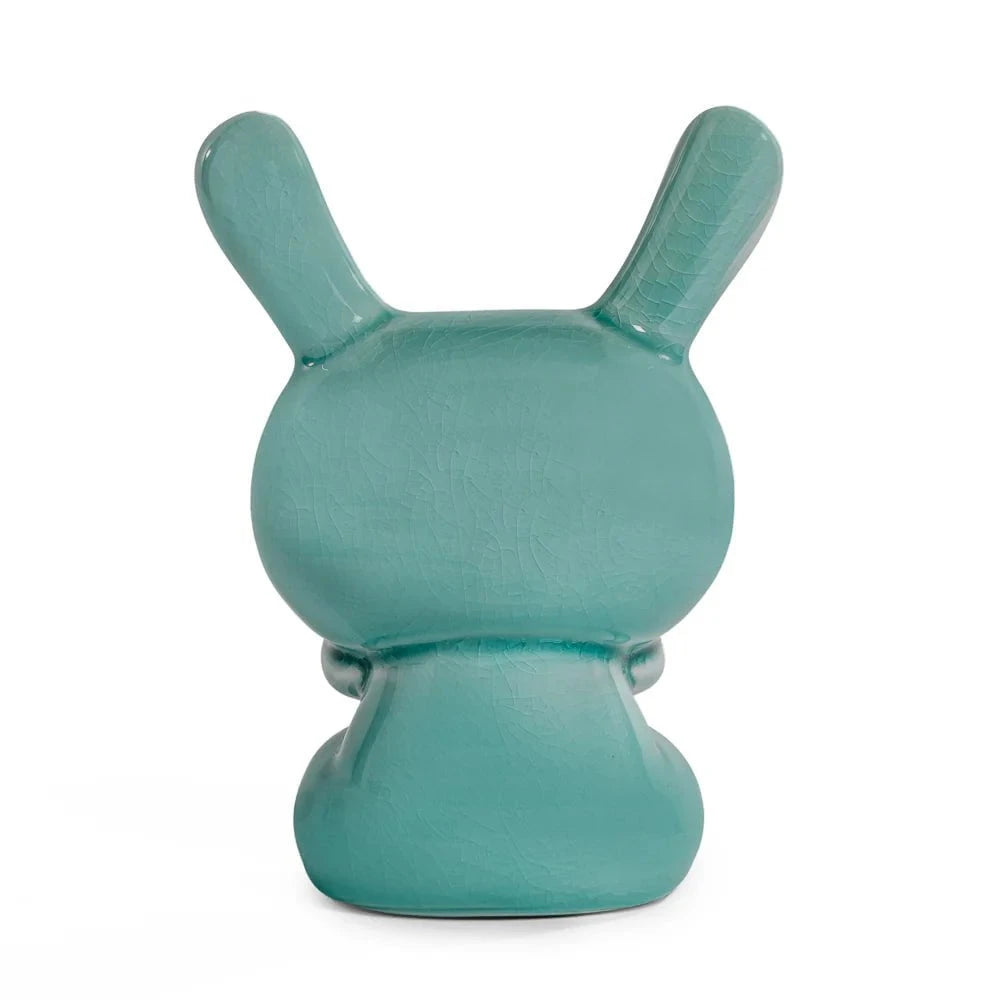 A blue mist crackle glazed Kidrobot Three Wise Dunnys 5” porcelain figure, viewed from the back with rabbit-like ears, showcases the brand’s iconic whimsical style against a plain white background.