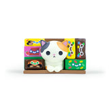 A small calico cat figurine from the 100% Soft Bodega Kitties — Series 1 Blind Box sits among colorful, patterned rectangular blocks on a brown base.