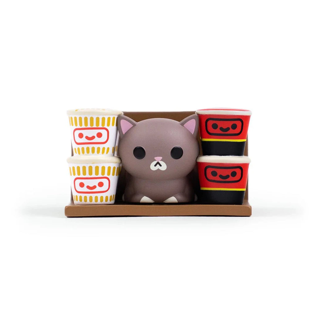 A small gray cat figurine from the 100% Soft Bodega Kitties — Series 1 Blind Box sits between two cartoon noodle and soup cups on a brown tray, set against a white background.