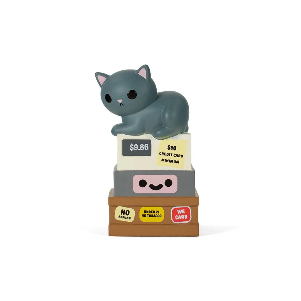 The Bodega Kitties — Series 2 Blind Box by 100% Soft features a quirky gray cat figurine on stacked blocks with bodega-style signs like 