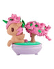 The tokidoki Botanical Bonsai Unicorno - Pink Bougainvillea Bonsai (Special Edition) features a small Unicorno with a flower on its head, displayed next to a pink-blossomed bonsai tree in a round lavender pot.