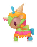 The Tokidoki Ice Cream Shop Unicorno - Neon Melty (Special Edition) by Tokidoki features colorful icing patterns, an ice cream cone on its head, and a blue tail, displayed against a white background.